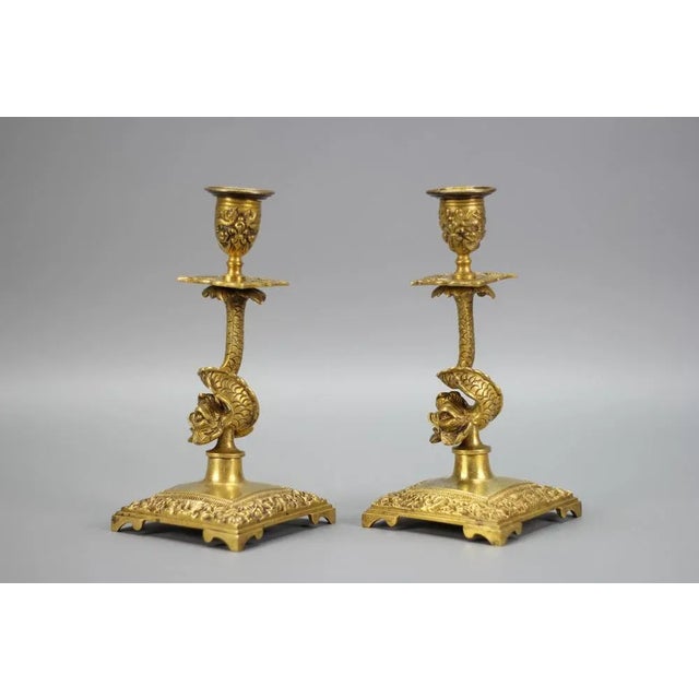 A pair of candle holders made of bronze, France, circa the 1930s. These beautiful bronze candlesticks each feature column...