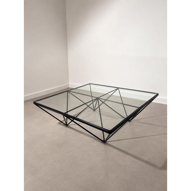 Striking postmodern coffee table - Paolo Piva , featuring a clear glass top supported by an architectural black metal...