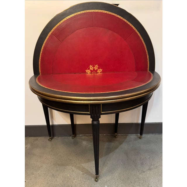 Convertible demilune console with 2 different interior surfaces. Closed it is a black painted demilune with brass trim and...