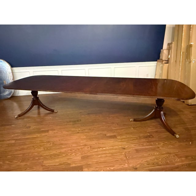 This is a traditional mahogany dining table made by Leighton Hall. It features a field of slip-matched swirly crotch...