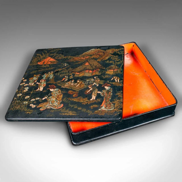 This is an antique presentation box. A Japanese, lacquered lidded case with hand painted Oriental decor, dating to the...