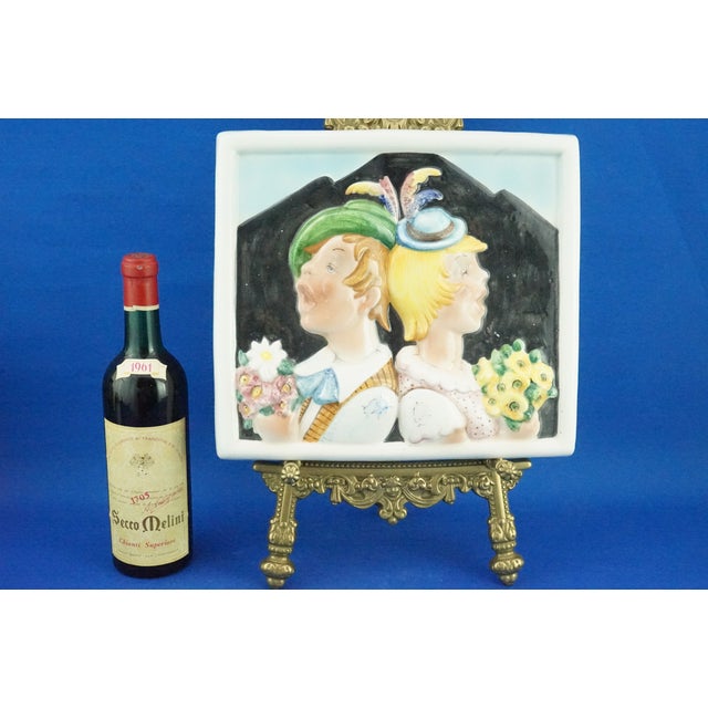 Item description: Cast ceramic plaque, also known as soft porcelain, i.e., ceramic with added kaolin, depicting a boy and...