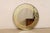 An artisan crafted round mirror with gold églomisé Greek key motif. This nicely sized and round-shaped mirror, with a...