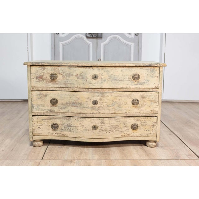 This 18th-century French painted commode, circa 1760, is a stunning example of antique craftsmanship and timeless...