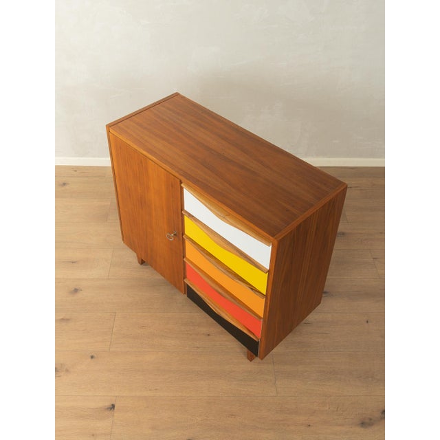 Unique chest of drawers from the 1960s. High-quality walnut veneer frame with five drawers in white, yellow, orange, red,...