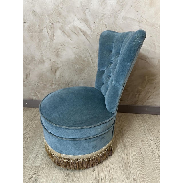 An elegant armchair dating from the 1950s, entirely upholstered in a beautiful blue velvet with subtle highlights. Its...