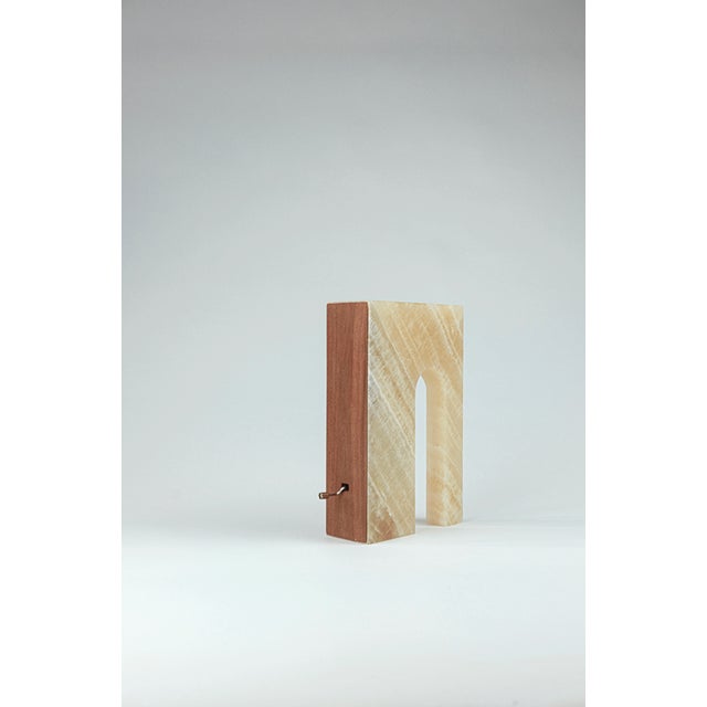 Music box in honey onyx and walnut wood transform the archetypal signs of dwelling into sound and material presence. The...