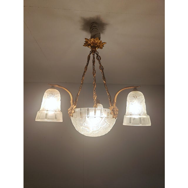 Bring timeless french elegance into your home with this magnificent art deco bronze and frosted glass chandelier....