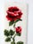 A vintage Shillcraft latch hook wall hanging featuring a bold red rose set against a soft ivory ground. The raised pile...