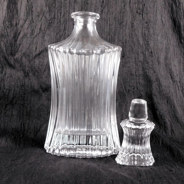 This is a ridged crystal decanter that is an unusual shape-wider at the top and bottom than the middle and narrow from...