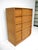 A five-drawer high boy dresser in the champagne finish model number M792 with the fronts having a wavy design motif and...