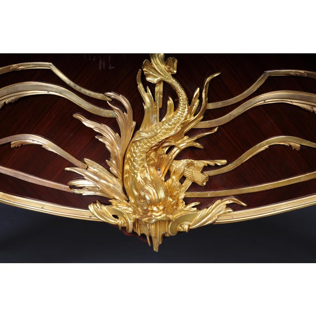 Finely chased, gilded fittings. Solid beech wood top panel mottled marble top above a pair of doors concealed by a laurel,...