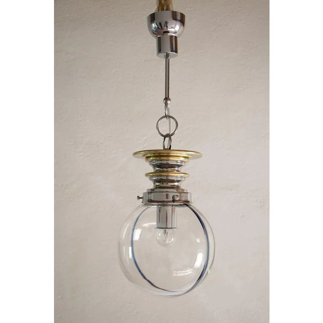 Particular Italian mid-century modern blown Murano glass, ball shape pendant lamp with the blue and yellow wire print,...