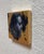 This oil on copper leaf piece presents a striking profile of a figure, rendered in deep, moody tones that contrast with...