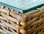 Each table features a tightly woven rattan body with warm honey tones, resting on short wood block feet, and topped with a...