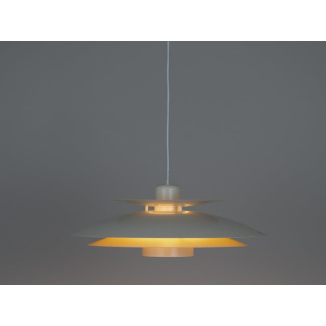 The lamp's form was designed based on the principle of a reflective system that directs light not only downward but also...