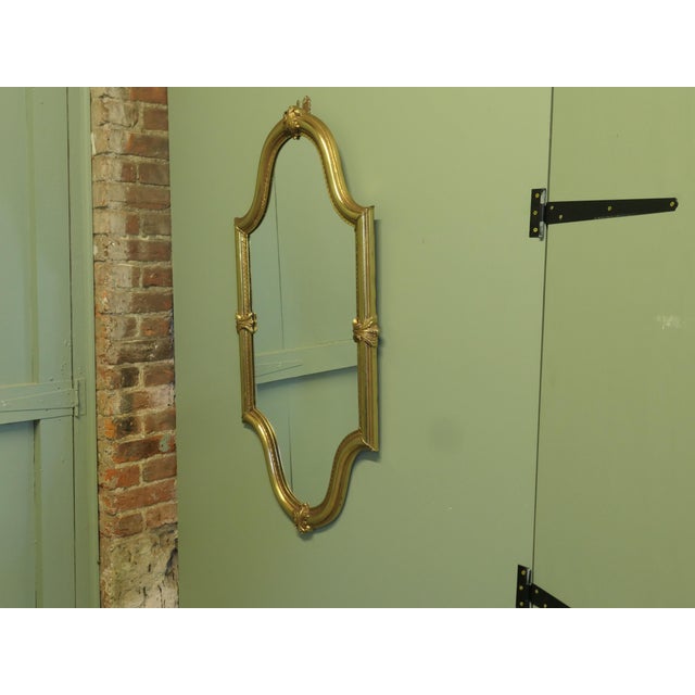 A Long Shaped Oval Brass Wall Mirror The Mirror has a decorative Acanthus Leaf motif around the brass Mirror frame The...
