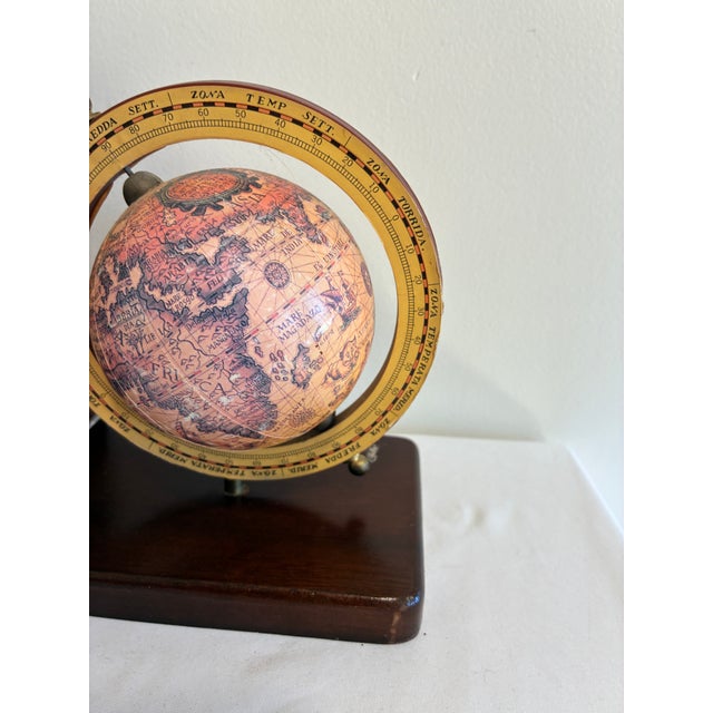A handsome pair of vintage wood bookends, each with a small antique-style globe set in a brass-tone ring. The globes show...