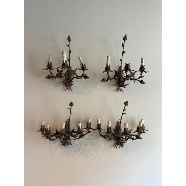 A set of antique iron sconces from 1900, gilded and adorned with botanical floral details, offering timeless elegance and...