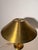 Elegant vintage table lamp crafted in brass, featuring a large conical shade with a distinctive perforated detail around...