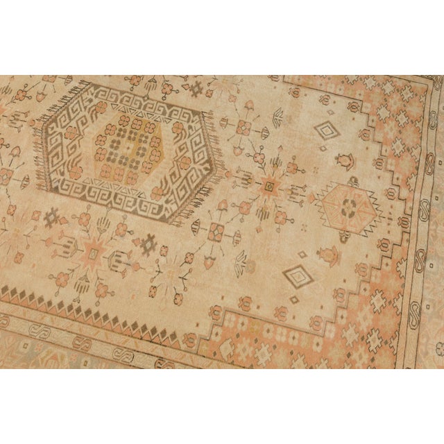 This is a vintage Turkish Oushak rug from the Mid 20th Century. The piece was hand-knotted.