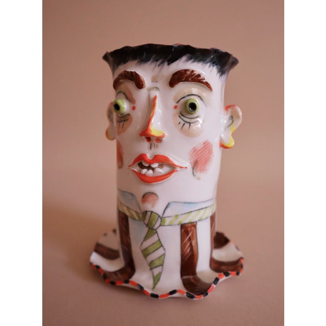 Petite porcelain vase with incredible detail work. Features expressive, wacky face with carefully crafted protruding eyes,...