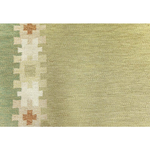 This vintage Swedish flatweave rug, designed by the acclaimed textile artist Ingegerd Silow circa 1956, beautifully...