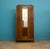 A 1930s oak wardrobe with a single mirrored door. The front features carved detailing. The base includes a full-width...