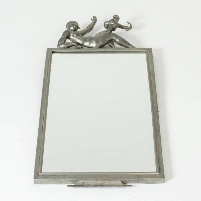 Stunning wall mirror by Thorwald Alef, made in pewter. The design is called “Amors spratt” (“Cupid’s Trick”). The top is...