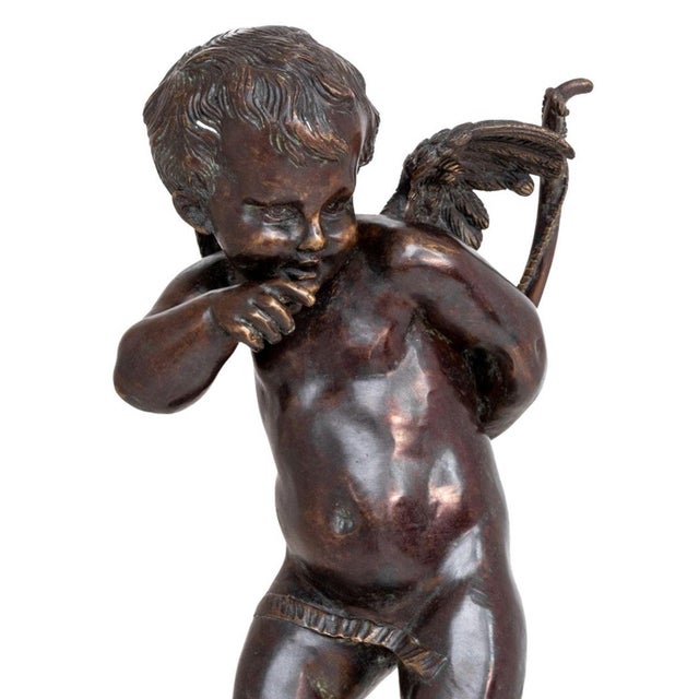 Neoclassical Patinated Bronze Figure of Cupid, 20th century, the standing figure holding their bow with the quiver at...