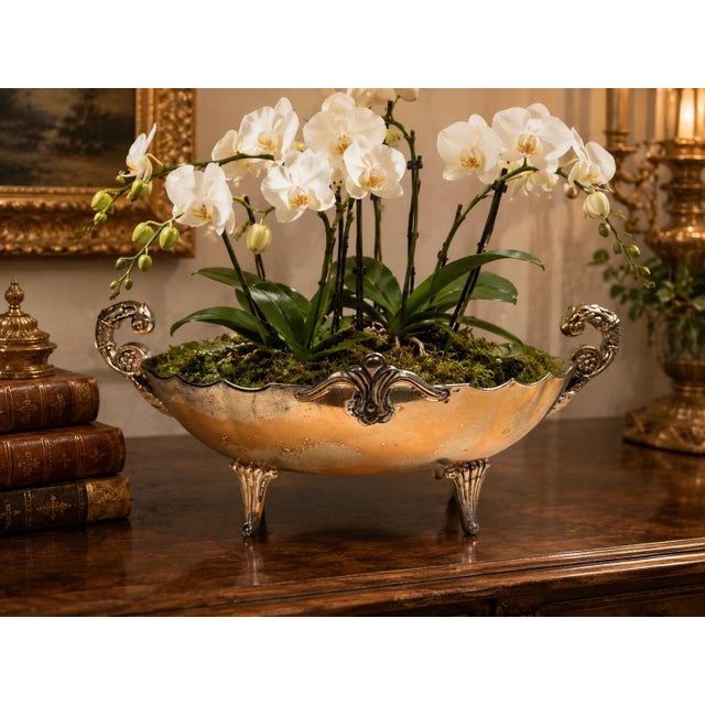 This elegant vintage silver-plated jardiniere combines sculptural detailing with timeless decorative appeal. Raised on...