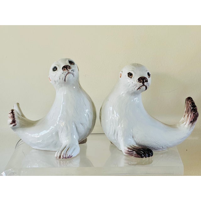 A pair of glazed terracotta figures in the form of seal pups. Finely modeled with expression and pose. Each inscribed...