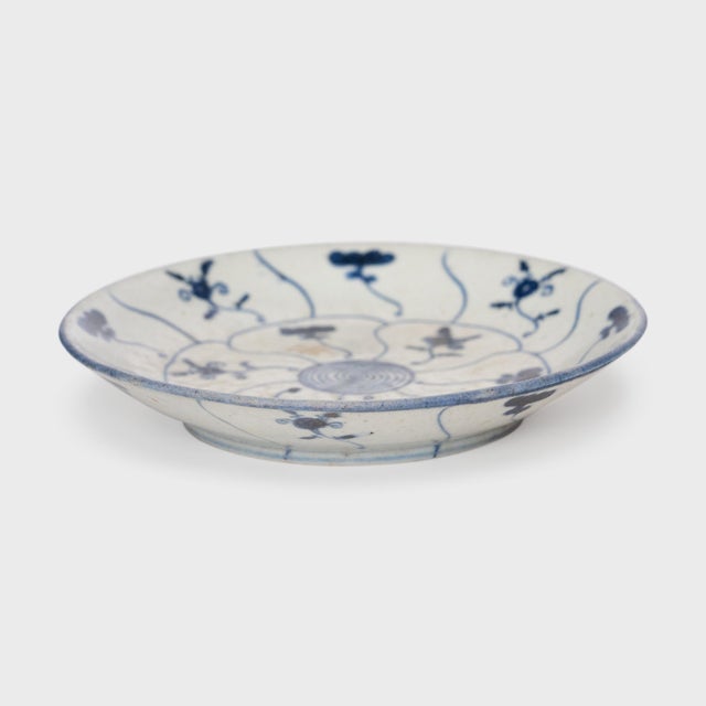 This 19th-century porcelain plate is hand-painted with cobalt underglaze in the blue-and-white manner, loosely brushed...