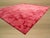 A 5' x 8' hand-knotted wool rug with a coral pink abstract with a deeper red marbled veining. Newly made in India. Size:...