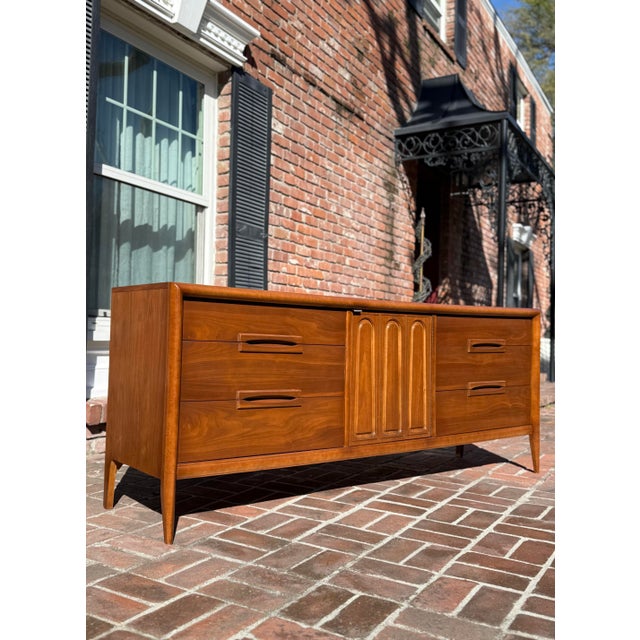 Large and lavish Mid Century Modern walnut dresser / credenza by Bassett for their “Outlook” collection. In fantastic...