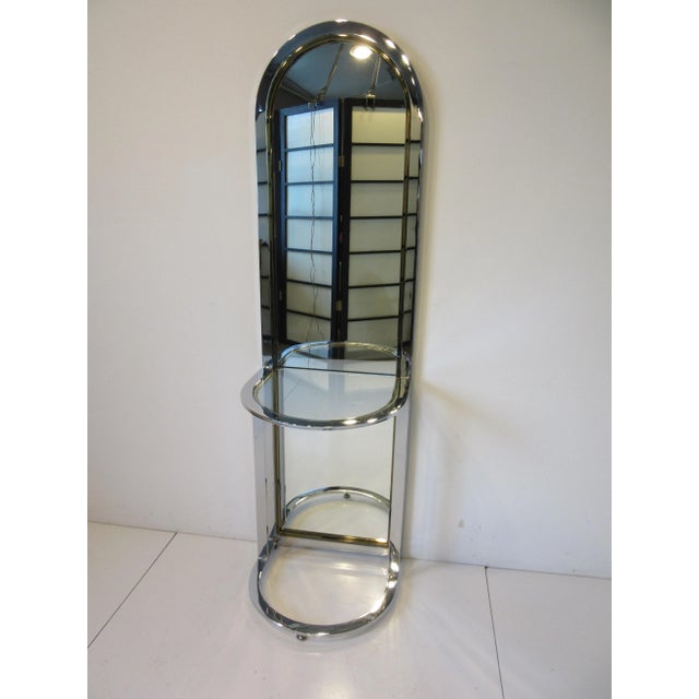 A exceptional and stunning arched topped standing Racetrack hall mirror in chromed steel having brass detailed accents...