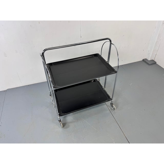 Bremshey Folding Bar Cart Trolley Germany 1960s Black Gerlinol plywood trays en Chromed steel frame with original castors....