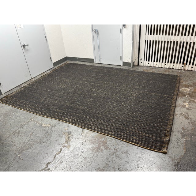 Design Plus Gallery presents a 9 ft × 12 ft Jute Area Rug from Pottery Barn. This woven rug has a black field accented by...
