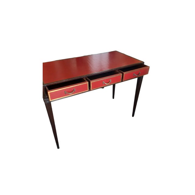 Vintage Directoire style wood and red leather topped writing desk. Desk has 3 drawers with brass pulls.