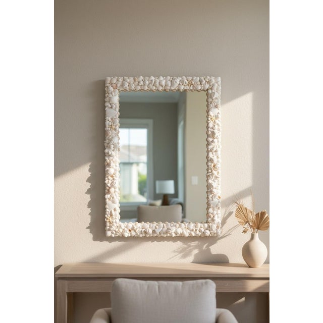 Coastal shell mirror in all-white natural shells, designed in layered tones of natural ivory and soft coastal white...