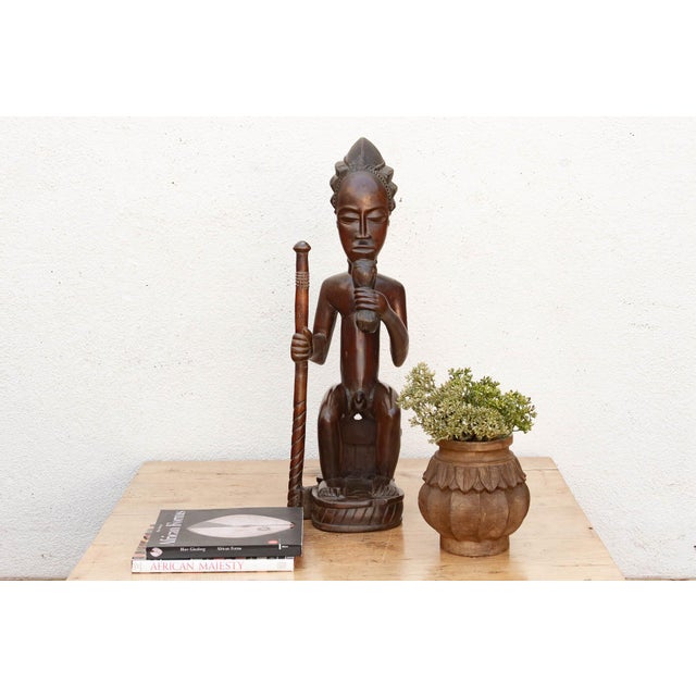 This seated figure depicts a Chokwe chief, or mwanangana — "lord of the land" — a title carrying both political authority...