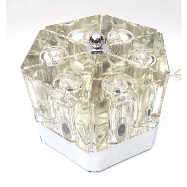 This glass table lamp features a stainless steel base and is composed of 6 thick 'clove' elements which each hold a lamp....