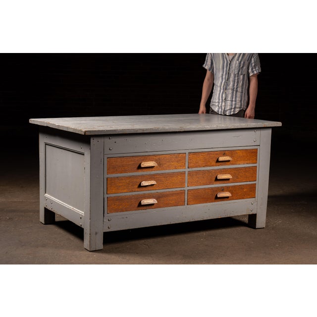 Heavy-duty wooden laboratory island or preparation table featuring a substantial painted frame fitted with six oversized...