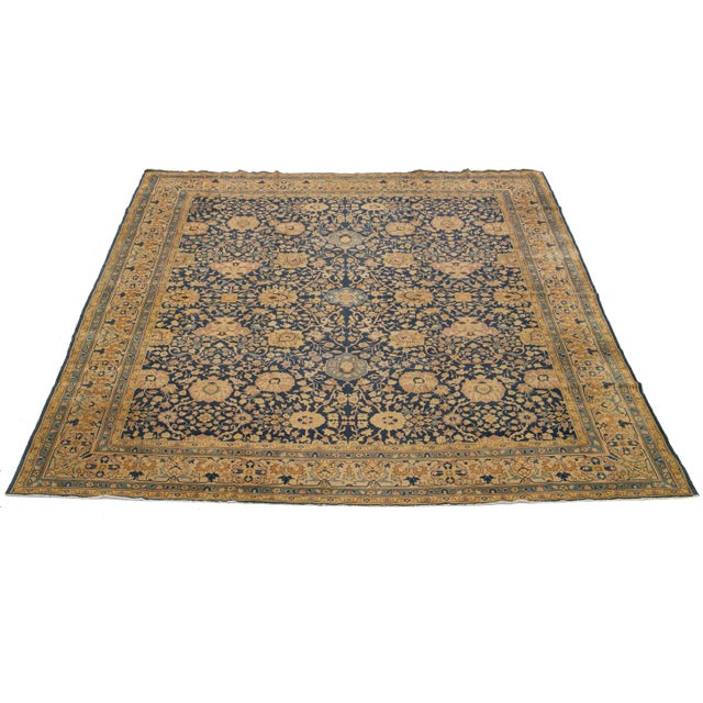 This antique Persian Tabriz rug, dating back to the 1880s, features a striking dark blue field embellished with a...