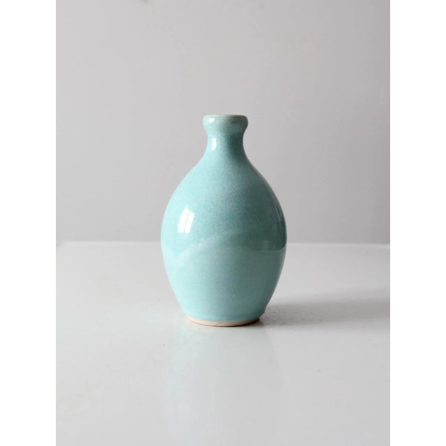This is a vintage studio pottery vase. Signed by the artist, the hand-crafted bottleneck vase has a robin's egg blue glaze.