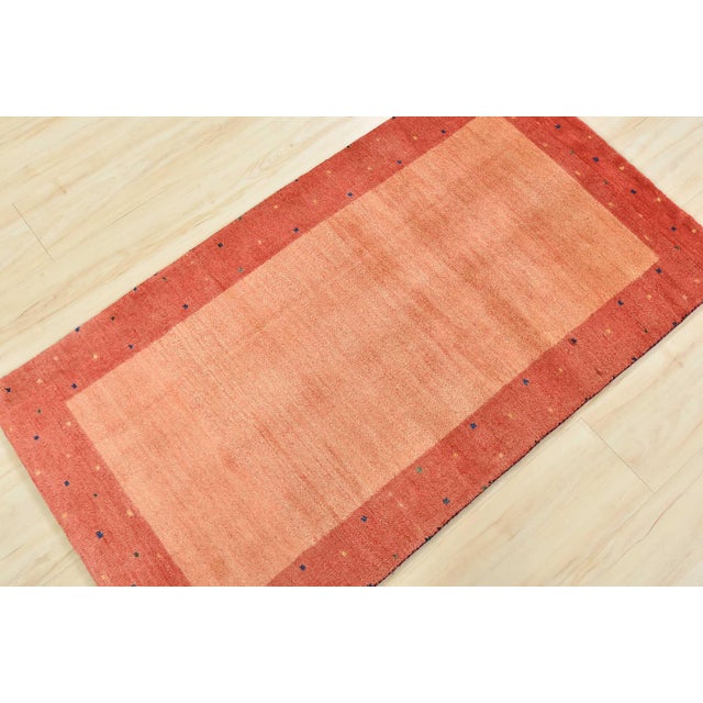 A contemporary Gabbeh rug hand-knotted with an all-wool pile on a cotton foundation. This finely woven rug features a...