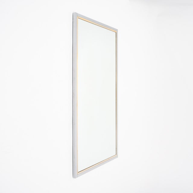 Mirror from France in the mid-century Modernist style. This sleek piece has a large central rectangular mirror bordered by...