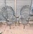 Offered for your consideration is a highly coveted, matched pair of vintage wrought iron peacock chairs, masterfully...
