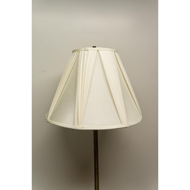 A mid 20th century modern brass finish floor lamp featuring a built in round surface at table height. The lamp has been...