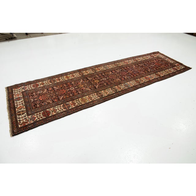 This beautiful 20th-century Malayer hand-knotted wool rug has a brown color field. It features stunning multicolor accents...